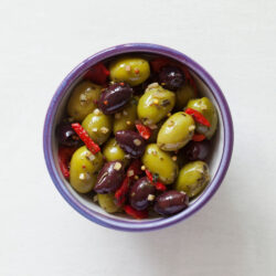 Garlic, peppers & mustard seed olives in a bowl