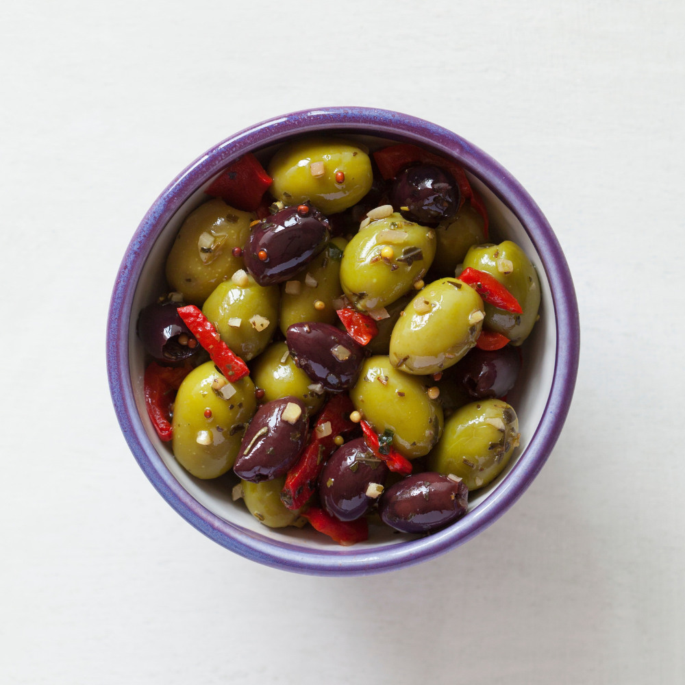 Garlic, peppers & mustard seed olives in a bowl